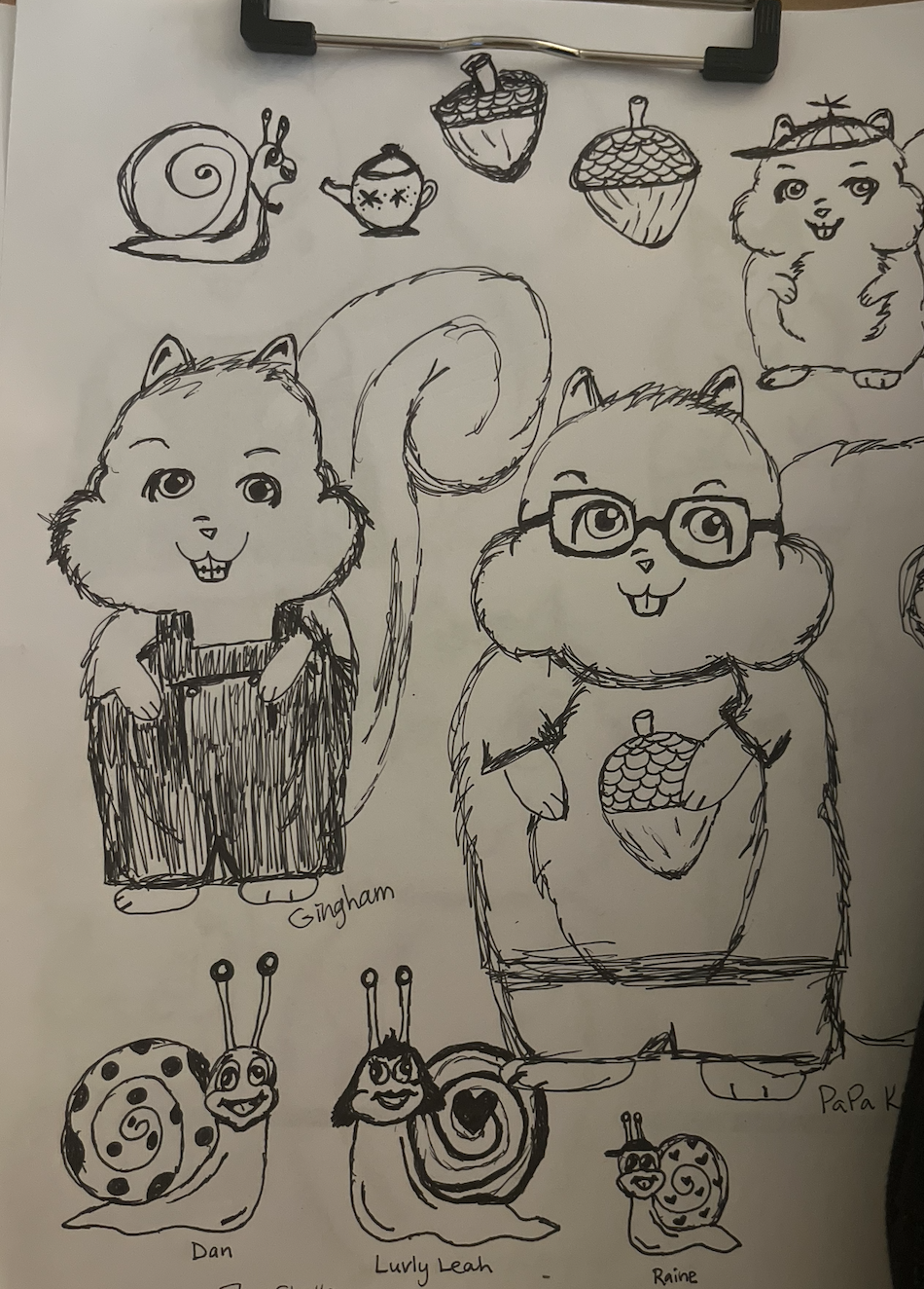 Pen and ink character sketches: two large squirrels, one in overalls and one wearing glasses and holding an acorn, surrounded by smaller drawings of acorns, a teacup, and three snails.